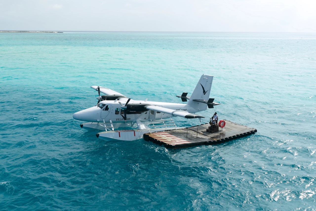 Hidroplan ob pomolu na turkiznem morju na Maldivih