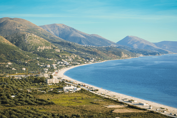 Najdaljša plaža v Albaniji, Borsh, s sedem kilometrov dolgo prodnato obalo, obdano z oljčnimi nasadi in zelenimi griči.