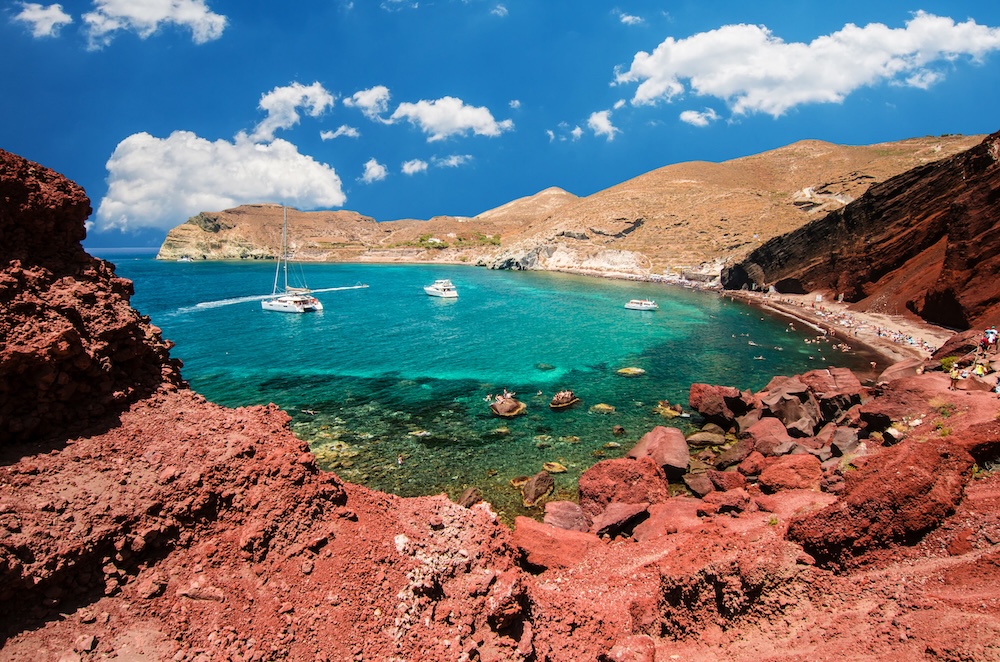Red Beach na Santoriniju – rdeči vulkanski klifi in temnejši pesek ob modrem morju