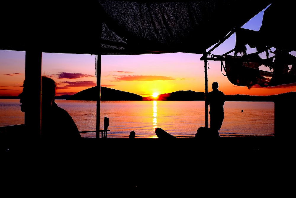 Skiathos v Grčiji: peščena plaža in miren zaliv v pastelnih barvah sončnega zahoda